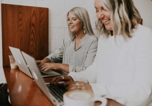 Laughing Businesswomen Working at Laptop